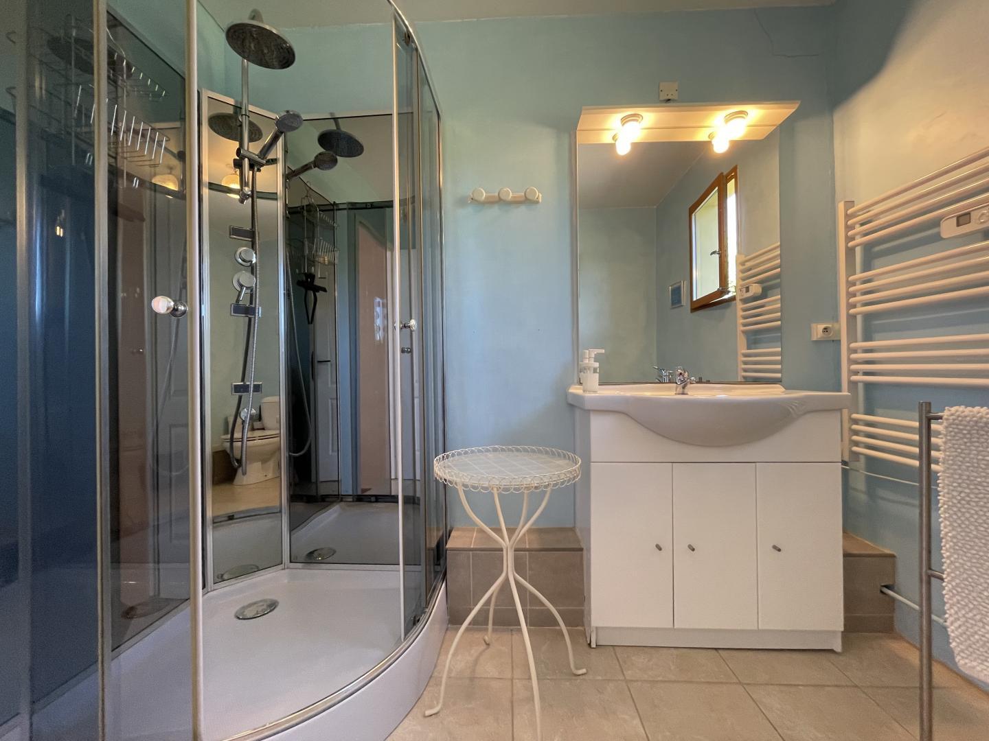 Family bathroom with large shower, heated towel rail and vanity unit at Maison Lajus holiday farmhouse, South West France