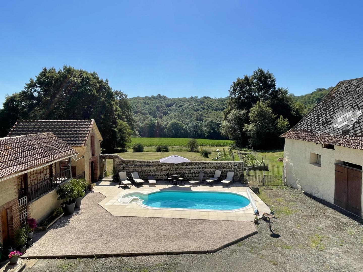 Aerial view of the private swimming pool, sun terrace with loungers and Béarn countryside backdrop at Maison Lajus holiday gîte, Pyrénées-Atlantiques